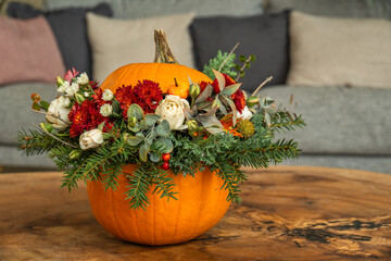 Pumpkin flower centerpiece with roses and greenery
