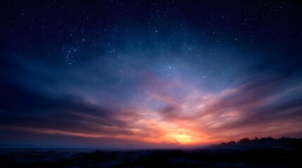 Fototapeta premium A serene twilight sky filled with countless stars and the vibrant glow of a setting sun over a dark landscape