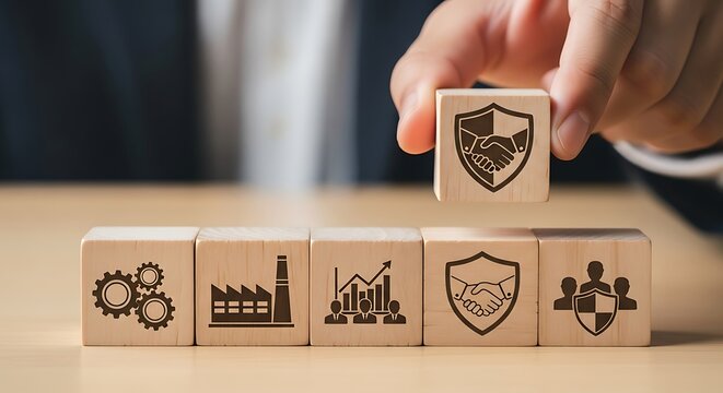 Hand placing wooden block with shield and handshake icon on top of others