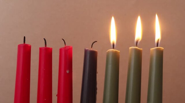 African American Kwanzaa holiday concept with traditional lit candles. Seven candles red, black and green