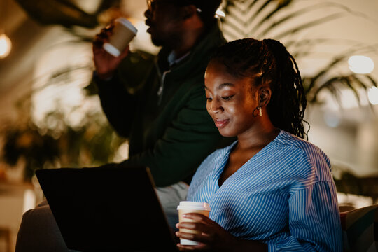 African american colleagues sharing coffee and working late - Powered by Adobe