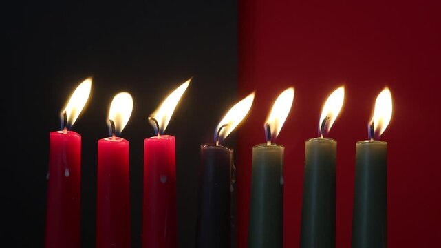 African American Kwanzaa holiday concept with traditional lit candles. Seven candles red, black and green