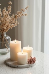 Elegant composition of white candles and dried flowers in soft natural lighting. Aesthetic home decor scene perfect for relaxation, hygge lifestyle, and minimalist interior inspiration
