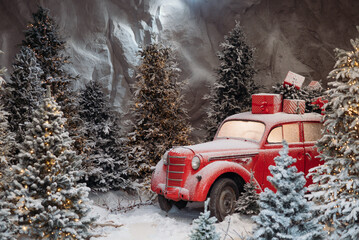 Vintage red car covered in snow with Christmas gifts on top, surrounded by snowy fir trees in a winter forest scene.