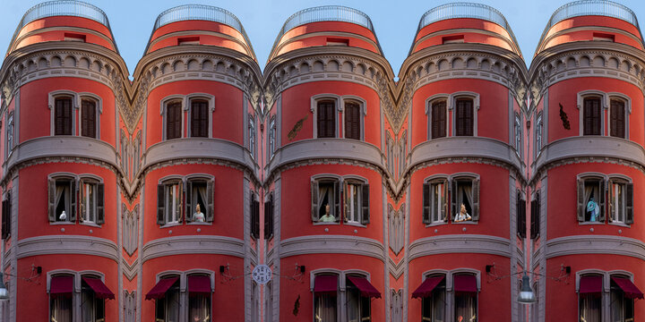 DREAM N°121 – Windows of Illusion. Surreal and conceptual artwork showing a mirrored red building with multiple identical façades and human figures wearing animal masks looking out from the windows.