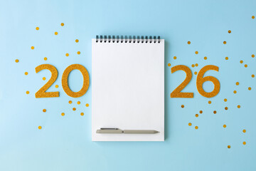 New Year 2026 planning concept with notebook and golden numbers for your goals, plans, resolutions. Flat lay style. Christmas planning concept with space for text