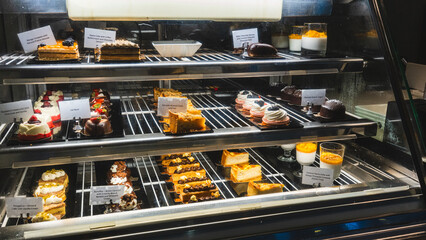 Beautiful cafe display case filled with exquisite pastries, cakes and desserts, ready to eat. Perfect for bakery promotions, cafe menus and food photography.