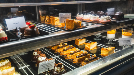 Beautiful cafe display case filled with exquisite pastries, cakes and desserts, ready to eat. Perfect for bakery promotions, cafe menus and food photography.