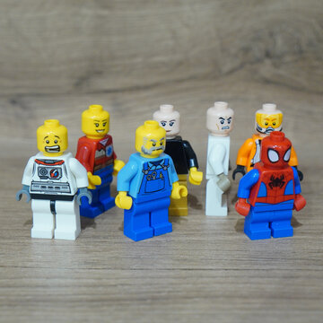 Collection of Lego minifigures standing together on a wooden surface