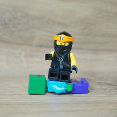 Naklejka premium Lego Ninjago minifigure with Minecraft and Lego blocks on a wooden surface