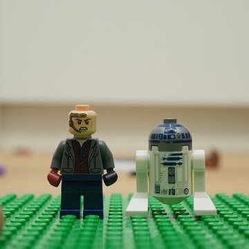 Lego Star Wars figures of a character and R2-D2 on a green baseplate