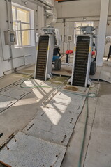 WWTP Coarse Mechanical Screening Hall. Two inclined mechanized bar screens with electric drives for removing large debris from wastewater.