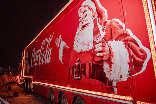 Klagenfurt, Austria - December 05, 2024: Coca Cola Christmas Truck Tour featuring Santa Claus, illuminated red truck with festive lights, creating a joyful holiday atmosphere for families and friends