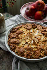 Homemade apple pie decorated with crust on wooden table in rustic kitchen.