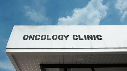 An oncology clinic word sign displayed on a specialized medical facility building under a clear blue sky, symbolizing cancer care, treatment, research, and patient support