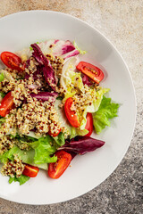 Quinoa salad tomato, green leaf salad vegetables dish natural product tasty snack fresh gourmet food background on the table rustic top view copy space keto and paleo diet vegan and vegan food