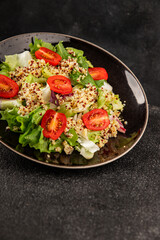 Quinoa salad tomato, green leaf salad vegetables dish natural product tasty snack fresh gourmet food background on the table rustic top view copy space keto and paleo diet vegan and vegan food