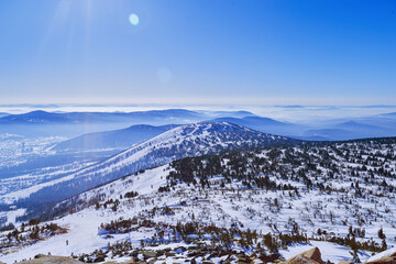 Aerial view of mountain ridges in soft fog and sky. Beautiful white blue peaks Altay mountains fades in distance. Minimal Nature abstract photo, natural winter picturesque scene, panoramic skyline.