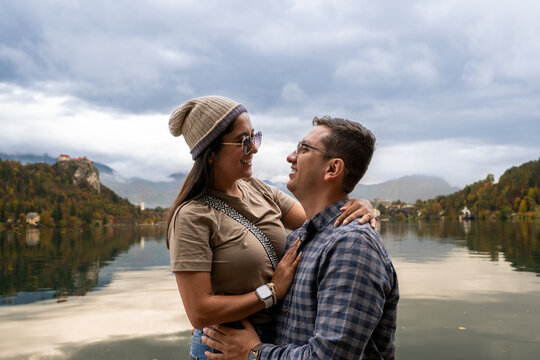 Young couple embracing during a romantic autumn moment at Lake Bled Slovenia with scenic background - Powered by Adobe