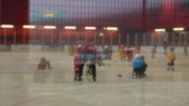 Blurry children on ice rink during hockey training, wearing protective gear and colorful jerseys, illustrating energy, teamwork, and playfulness of youth sports
