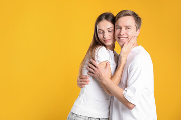 Naklejka premium Lovely couple hugging on yellow background, space for text. Romantic date