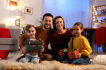Happy family with Christmas gifts on floor in festive decorated room