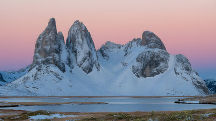 Snow- Covered Mountain Peaks Reflecting in a Calm Lake at Dusk