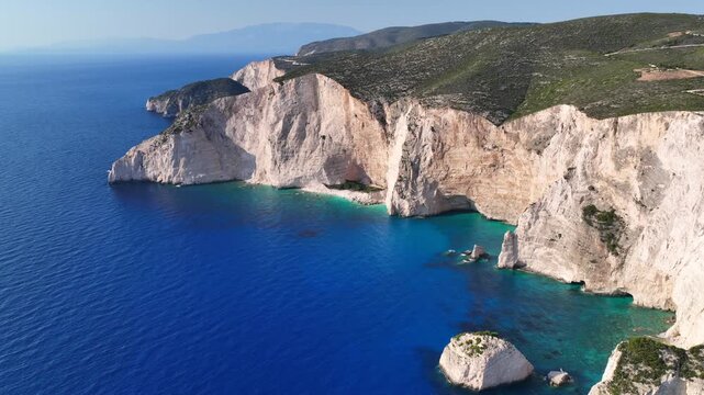 Aerial drone cinematic video of white beach consisting of volcanic caves and white steep hill near famous shipwreck cove a wonder of nature, Zakinthos island, Ionian, Greece