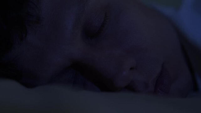 Man in REM sleep, rapid eye movement under closed eyelids, deep dreaming phase