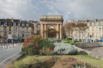 Flower bed in fall in front of triumphal arch. Bordeaux, France