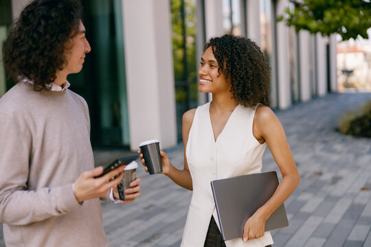 colleagues sharing ideas outdoors, casual meeting of professionals exchanging thoughts on city - Powered by Adobe