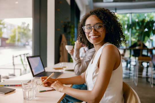 friendly work discussion, woman chats over coffee, charming cafe setting with productive team