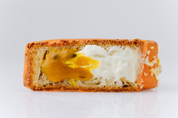 Croissant with orange glaze and creamy mango filling isolated on white background