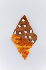Crispy croissant with milk chocolate glaze and marshmallow topping on white background