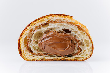 Close-up of croissant cross-section filled with creamy chocolate hazelnut spread