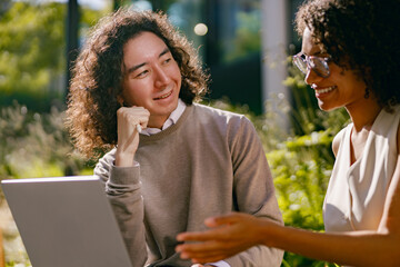 black coach mentoring white learner, black mentor guides white student in natural green environment