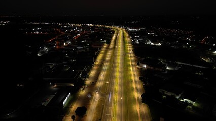 The elevated perspective showcases the illuminated road, with streaks of light from passing...