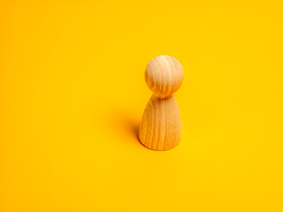 Wooden person figure representing individuality on a yellow background