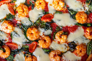 Pizza with shrimp, tomatoes and spinach, close-up. Mediterranean pizza texture background