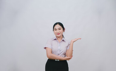 Confident business woman presenting with a smile, wearing a professional outfit against a neutral background, ready to engage and showcase her expertise and services.