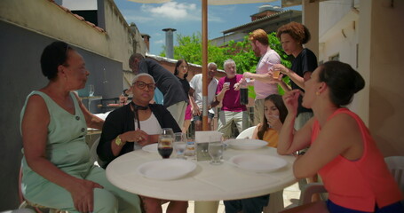 Joyful family gathering on a sunny patio, multigenerational group enjoying lunch, bonding through conversation, laughter, and shared moments of connection and togetherness