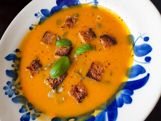 Delicious pumpkin soup with basil and toasted croutons
