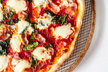 Pizza with bacon, tomatoes, spinach and cheese, close-up. Pizza textured background.