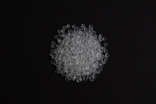 Virgin Polystyrene granules on dark background, top view. General Purpose Polystyrene (GPPS) or Crystal PS. Granulated plastic polymer