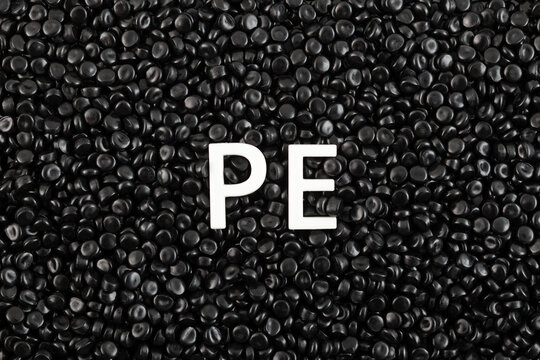 Black masterbatch or black coloured polyethylene granules, close-up. Granulated plastic compound. Virgin polymer dyed with carbon pigment. Polyethylene or polythene most commonly produced plastic