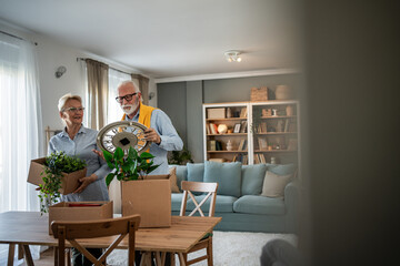 Senior couple unpacking moving boxes in new home