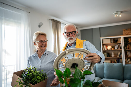 Senior couple downsizing, carefully packing and moving belongings
