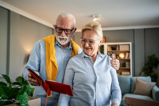 Senior couple reminiscing memories while packing for moving