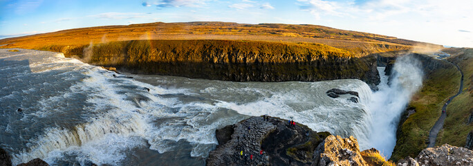 Gullfoss waterfall in Iceland showcases powerful cascades flowing into a canyon. Visitors admire...
