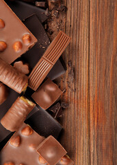 Chocolate products of different types on a colored background close-up with a place for text . Vertical photo format
